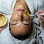 Contact A woman enjoying a gold facial mask for relaxation and skincare at a spa.